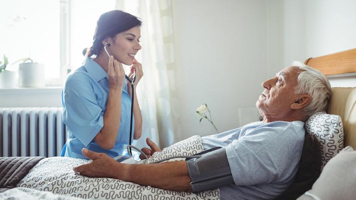 A compassionate nurse checking an elderly patient's blood pressure in a care home, ensuring their well-being.