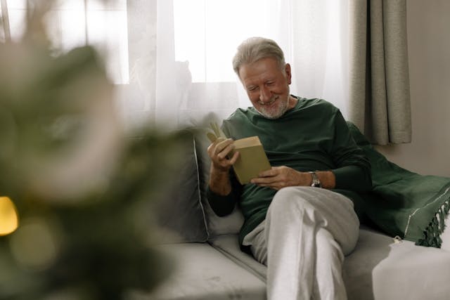 residential resident reading a book smiling