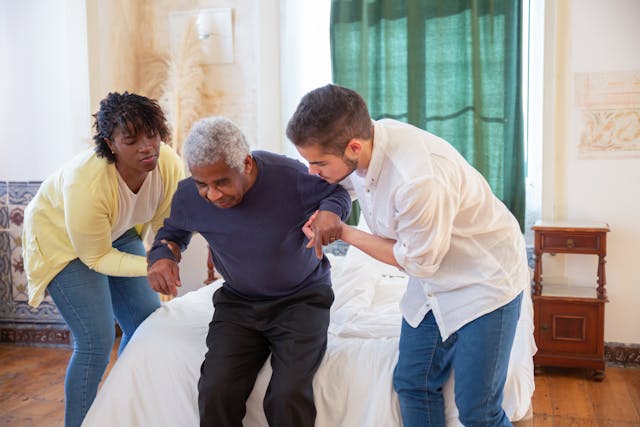 resident being helped up out of bed