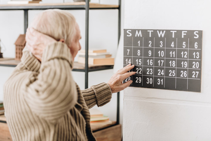 man with grey hair looking at a calendar