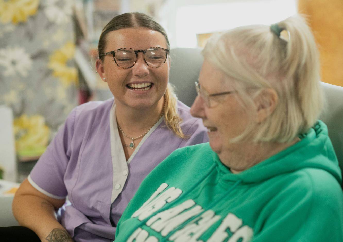 care staff member smiling and laughing with resident