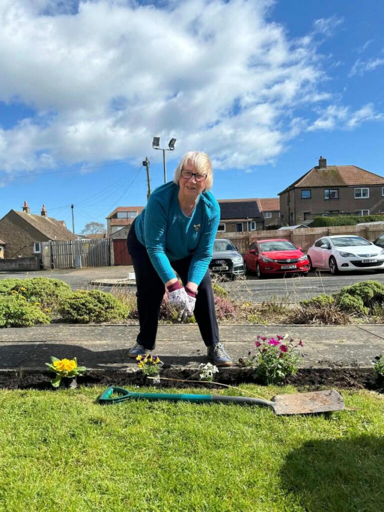 woman bent over to plant in garden