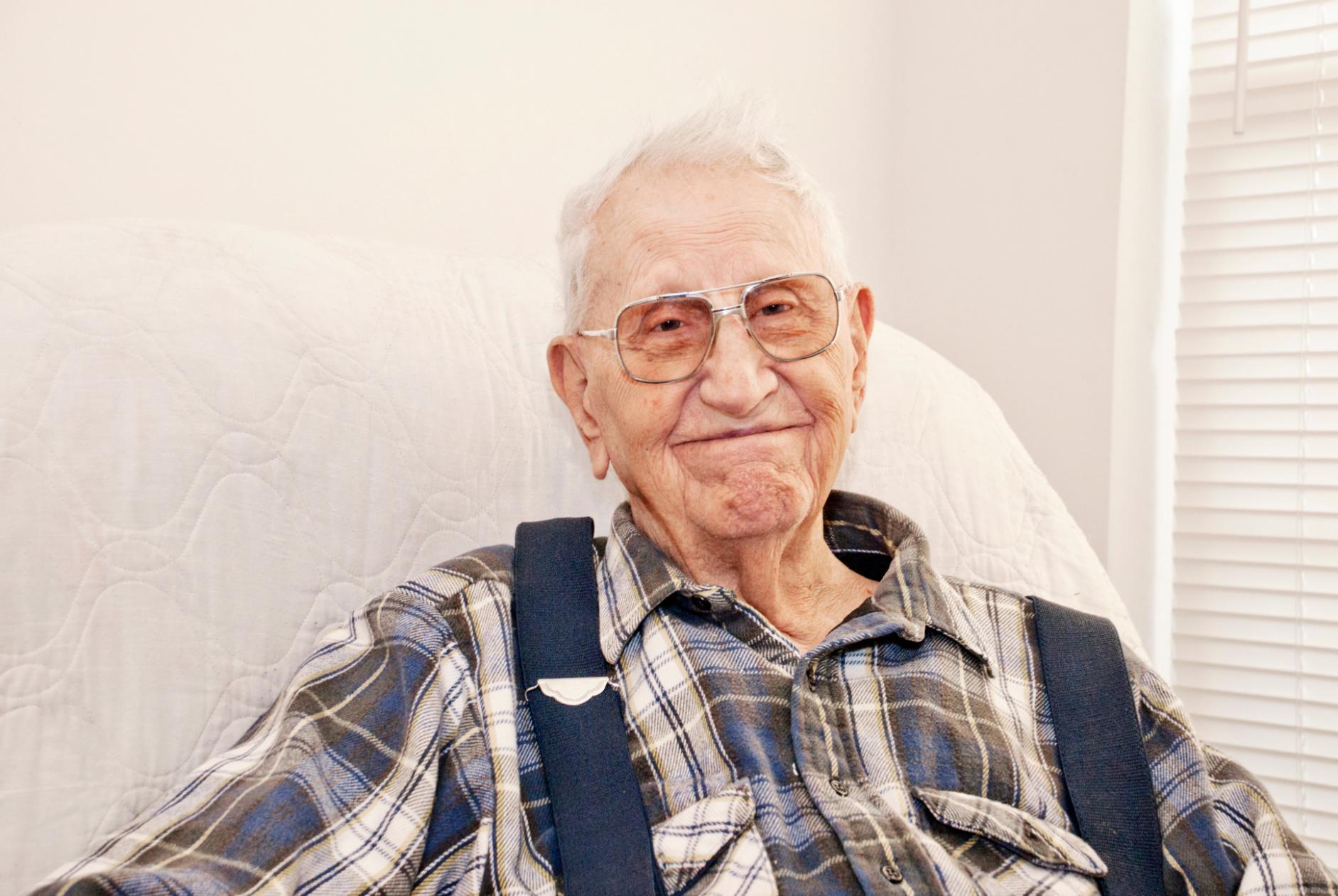 elderly man smiling in an armchair