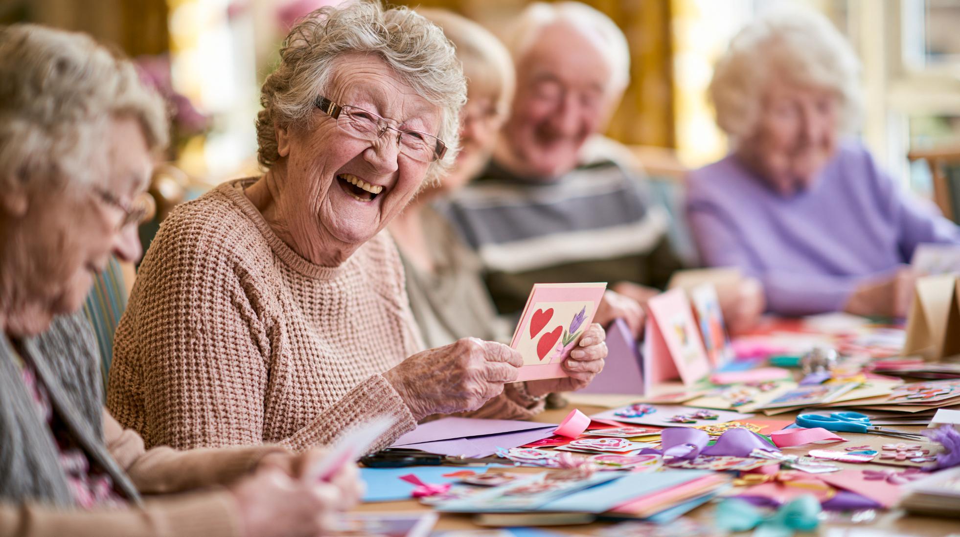 elderly woman laughing during a care home craft activity